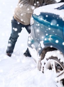 32779370 - closeup of man pushing car stuck in snow